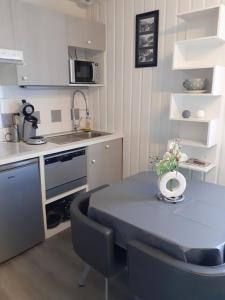 巴里吉斯Studio LE COL DU TOURMALET 2-4 pers linge parking wifi的小厨房配有蓝色的桌子和椅子