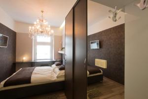 萨格勒布皮乌时尚客房的一间卧室配有一张床和一个吊灯