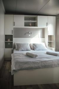 帕科坦Rasin Mobile Homes的卧室配有白色大床和白色橱柜