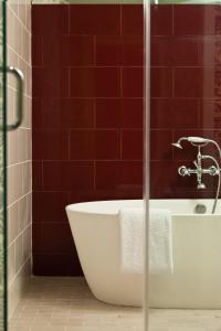 费城费城摩纳哥金普顿酒店的带浴缸的浴室,铺有红色瓷砖