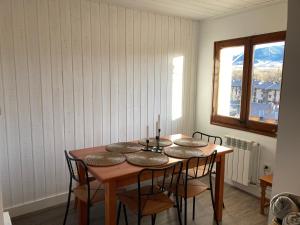 利维亚Vistas Únicas a los Pirineos, para 7-8 personas!! Tensi Home Llivia的一间带桌椅和窗户的用餐室