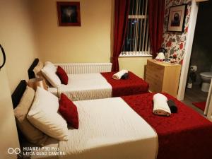 Blytheoddfellowsbandb的一间卧室配有两张红色和白色床单