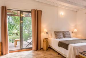 拉帕洛马La Maison Suites & Gastronomía的一间卧室设有一张床和一个滑动玻璃门