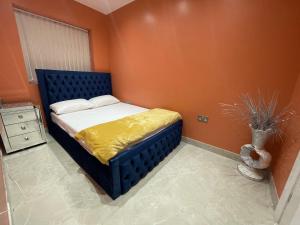 哈罗Modern Garden House的一间卧室配有一张橙色墙壁的床
