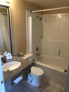 戈尔登塞尔柯克汽车旅馆的浴室配有盥洗盆、卫生间和浴缸。