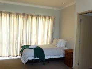 KarapiroKauri Lodge Karapiro的一间卧室设有一张床和一个大窗户
