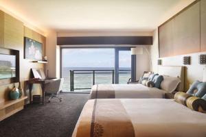 塔穆宁达斯特塔尼关岛度假村的酒店客房设有两张床,享有海景。