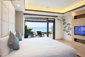 塔穆宁达斯特塔尼关岛度假村的一间带一张床和电视的卧室,享有海景