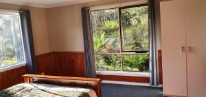 Moina高山摇篮度假住宿加早餐旅馆的一间卧室设有一张床和两个大窗户