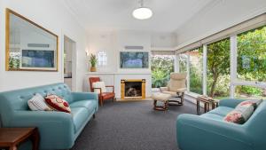 WendoureeLake side, opposite botanical gardens! Views!的客厅配有蓝色的家具和壁炉