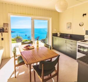 凯特里特里Incredible Bay Views - Kaiteriteri Bach的一间厨房和带桌子的海景用餐室