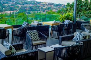基加利Onomo Hotel Kigali的庭院设有藤椅和桌子,享有美景。