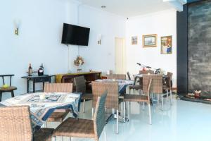 马卡萨Ge JacMart Homestay Makassar的一间带桌椅和电视的用餐室
