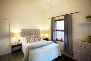 NuyLeipzig Country House & Winery的一间卧室设有一张大床和一个窗户。