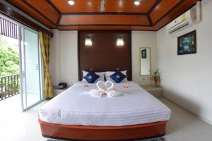 拉威海滩Vivi Boutique Room Hotel SHA Plus的一间卧室配有一张大床,床上放着鲜花