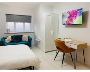 EtruriaTownhouse PLUS @ Lower Beth Street Stoke的一间卧室配有一张床、一张桌子和一张沙发