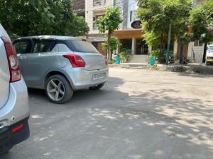 阿姆利则Hotel Amritsar International的停在街道边的银色汽车