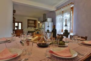 特拉诺瓦-布拉乔利尼Podere Il Doccio的餐桌,上面有玻璃杯和盘子