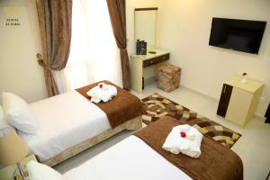 开罗Jewel Dokki Hotel的酒店客房设有两张床和电视。
