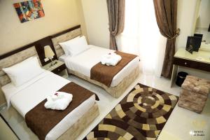 开罗Jewel Dokki Hotel的酒店客房,配有两张带毛巾的床