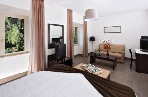 罗马LH Hotel Excel Roma Montemario的酒店客房设有床和客厅。