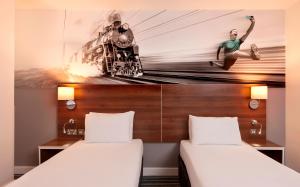 利物浦Heeton Concept Hotel - City Centre Liverpool的一张挂有火车壁画的房间的两张床