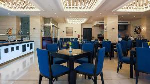 阿可贺巴The Proud Hotel Al Khobar的一间设有蓝色椅子和桌子的餐厅