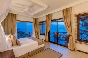 桑给巴尔海崖水疗度假酒店的一间卧室配有一张床,享有海景