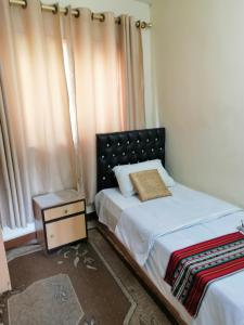 安曼哈穆达酒店的一间卧室配有床和带窗帘的窗户