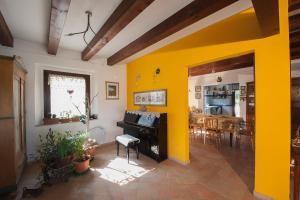 OffagnaB&B Punto Magico的客厅设有黄色的墙壁和钢琴