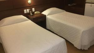 多拉杜斯巴哈马斯酒店的配有白色床单的酒店客房内的两张床