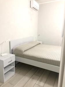 那不勒斯One bedroom apartement with wifi at Napoli的一间白色卧室,配有床和床头柜