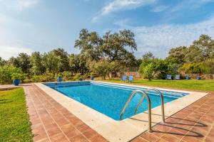 科迪加纳4 bedrooms villa with private pool and enclosed garden at Cortegana的庭院内的游泳池,带椅子和树木