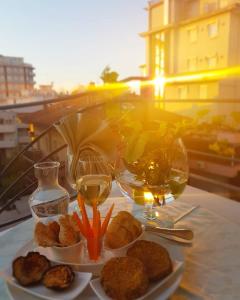 里米尼HOTEL ROMANTICA的餐桌,带食物盘和酒杯