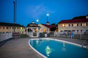欧塞奇比奇欧塞奇湾泳滩美洲最佳价值酒店的一座游泳池,在晚上在建筑物前