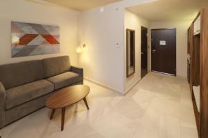 蒙特雷Holiday Inn & Suites - Monterrey Apodaca Zona Airport, an IHG Hotel的客厅配有沙发和桌子