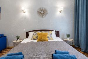 利沃夫Райська Насолода的一间卧室配有一张带蓝色和黄色枕头的大床
