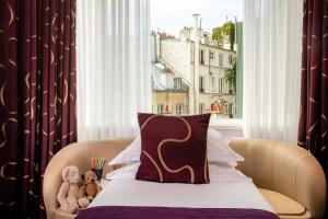 巴黎艾弗爱尔住宅酒店的两只泰迪熊坐在窗前的床上
