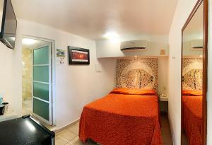 翡翠海岸本吉瑟斯酒店的一间小卧室,配有一张床和镜子