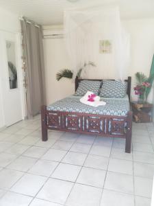 莱特鲁瓦西莱PARADIS TURQUOISE LOCATIONS的一张位于白色瓷砖地板的房间的床铺