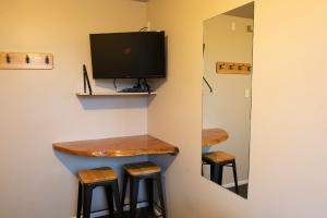 凯库拉Dusky Lodge的一间酒吧,房间设有两张凳子和一台电视