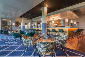 史基浦Radisson Blu Hotel Amsterdam Airport, Schiphol的一间带椅子的用餐室和一间酒吧