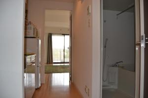 鹿儿岛格拉西亚斯公寓的客房设有带冰箱的走廊和厨房