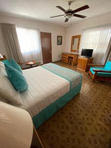 库埃纳瓦卡弗洛蕾丝花园酒店的一间卧室配有一张大床和吊扇