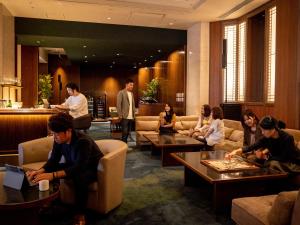 熊本The New Hotel Kumamoto -DLIGHT LIFE & HOTELS-的一群坐在酒店大堂的人