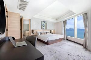 香港九龙海逸君绰酒店的一间卧室配有一张床和一张带笔记本电脑的书桌