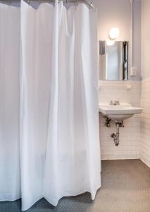 纽约里奥住宅酒店的浴室内白色的淋浴帘和水槽