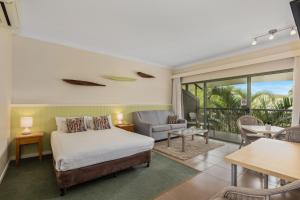 巴利纳Ballina Beach Resort的一间卧室设有一张床和一间客厅。