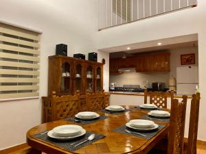 瓜纳华托La Casa de la Glorieta的厨房配有木桌和盘子