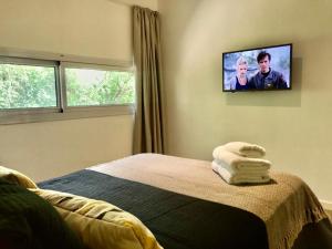 梅洛Cabañas Ambay的卧室配有一张床,墙上配有电视。